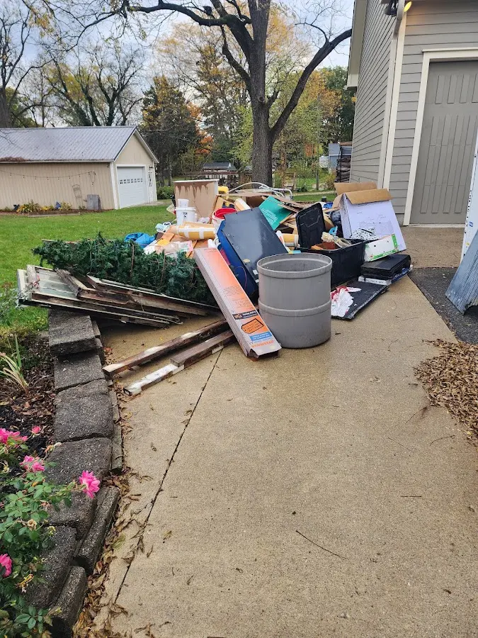 Dumpster being loaded with debris for 12 Yard Dumpster Rental in Monroe